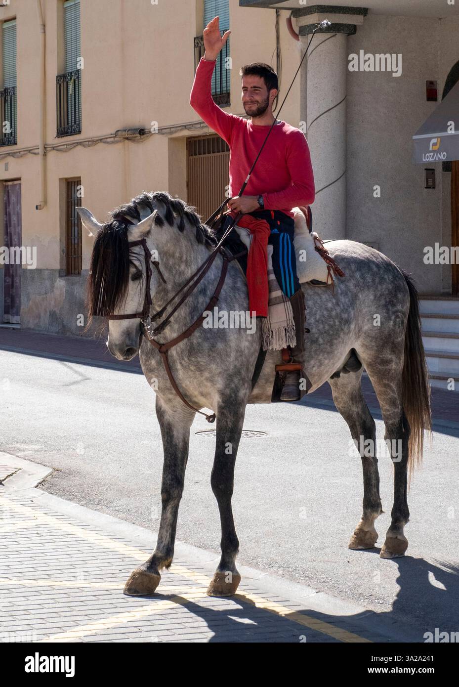 Giovane spagnolo a cavallo di un cavallo grigio nella città di Salar, Andalusia, Spagna Foto Stock