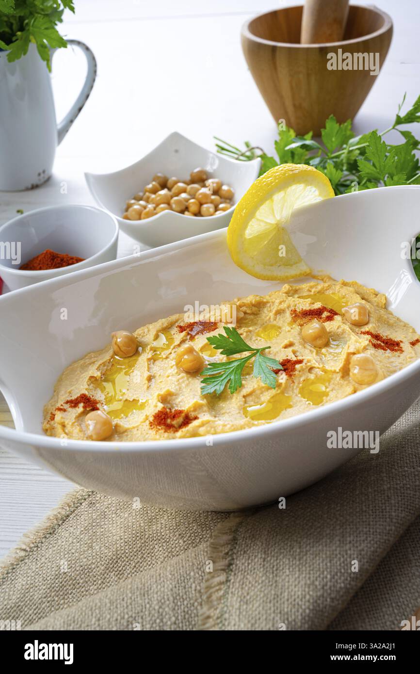 Pasta di hummus con limone e peperoncino su sfondo bianco Foto Stock