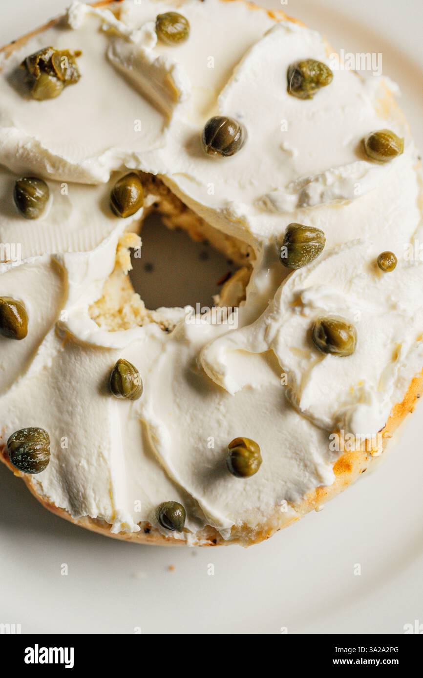 capperi su bagel metà con crema di formaggio Foto Stock