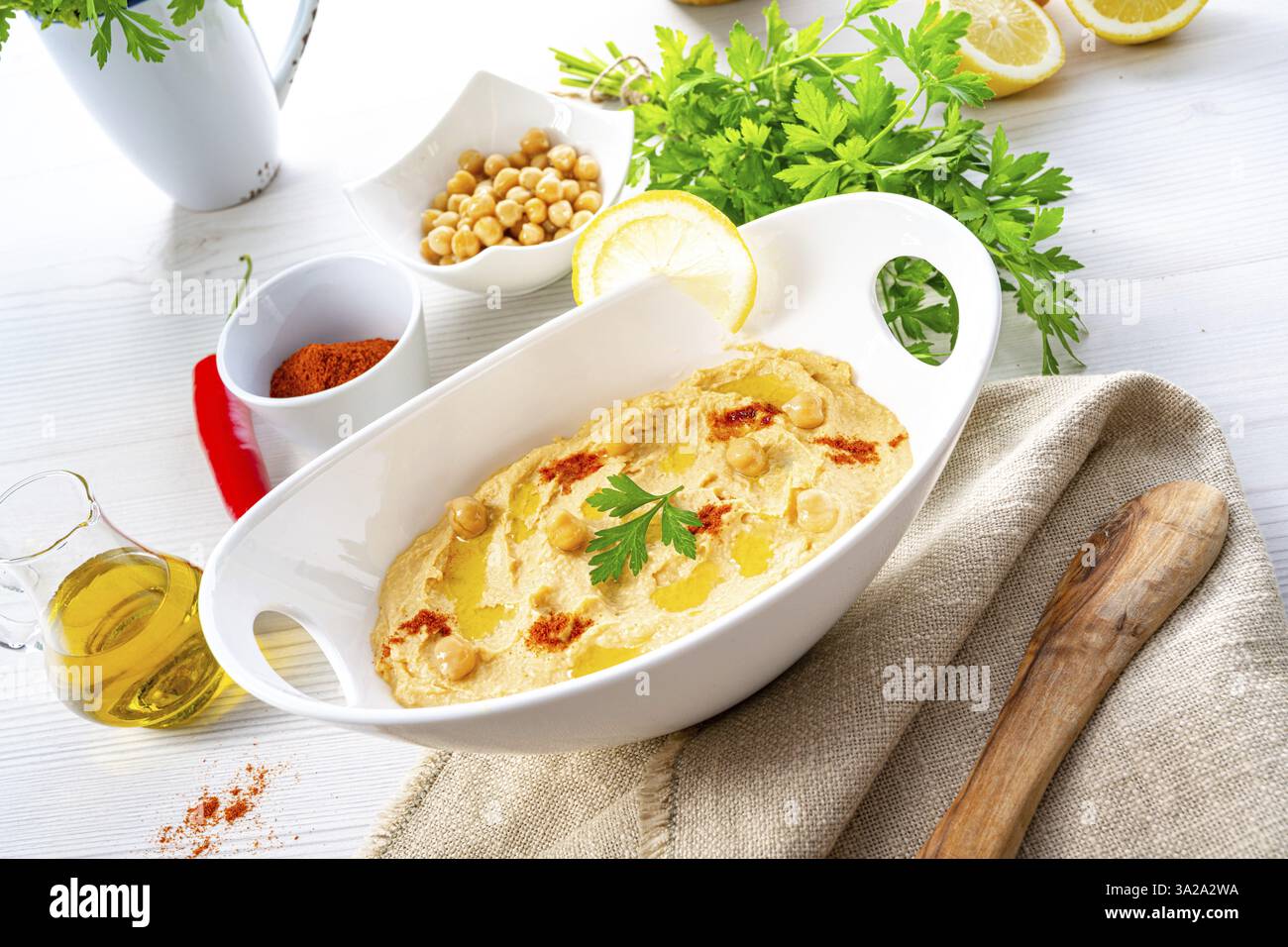 Pasta di hummus con limone e peperoncino su sfondo bianco Foto Stock