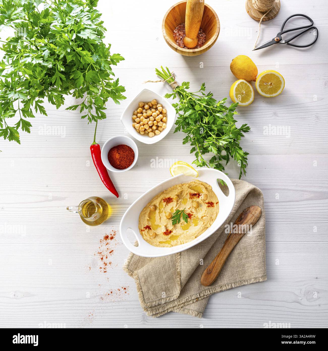 Pasta di hummus con limone e peperoncino su sfondo bianco Foto Stock