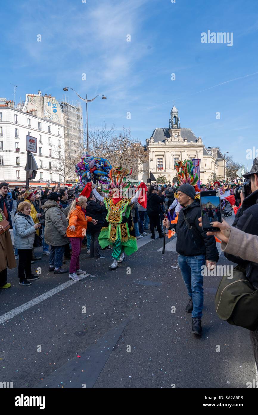 Costumi colorati e partecipanti gioiosi danno vita al Carnevale di Parigi 2025 in una luminosa giornata invernale Foto Stock