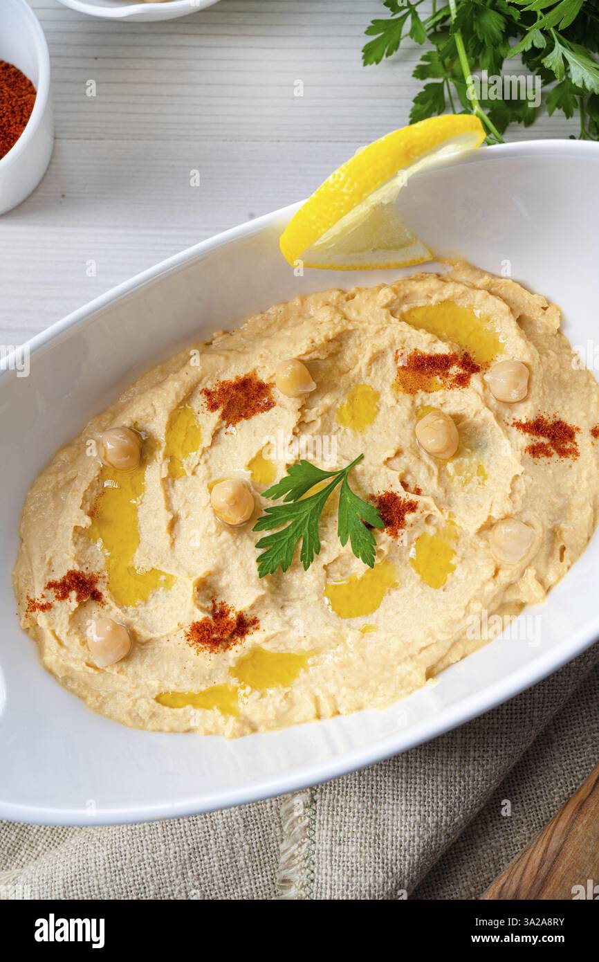 Pasta di hummus con limone e peperoncino su sfondo bianco Foto Stock