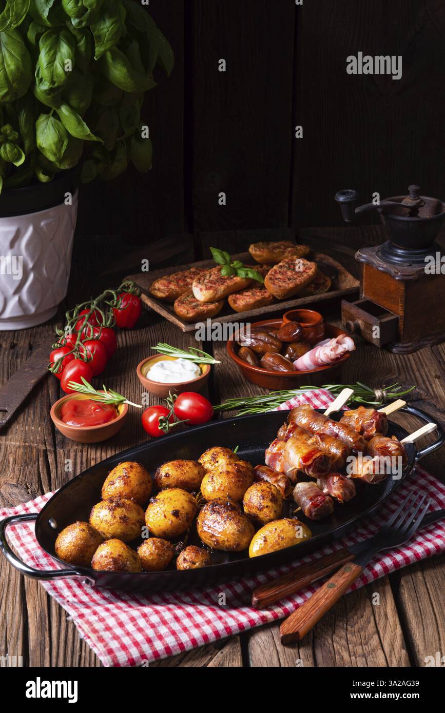 Datteri rustici avvolti in pancetta e patate arrosto giovani Foto Stock