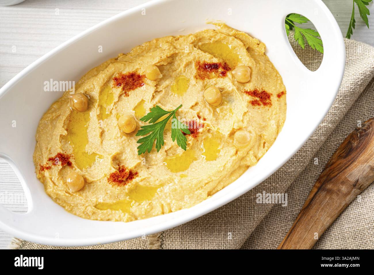 Pasta di hummus con limone e peperoncino su sfondo bianco Foto Stock