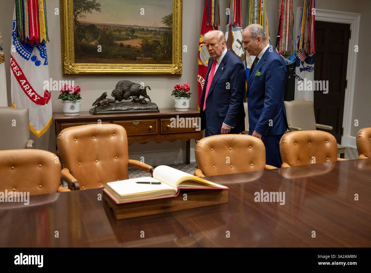 Washington, Stati Uniti. 12 marzo 2025. U. Il presidente Donald Trump, a sinistra, cammina con il Taoiseach irlandese Micheal Martin, a destra, per firmare il libro degli ospiti durante la tradizionale visita del giorno di San Patrizio presso la Cabinet Room della Casa Bianca, 12 marzo 2025 a Washington, DC Credit: Daniel Torok/White House Photo/Alamy Live News Foto Stock
