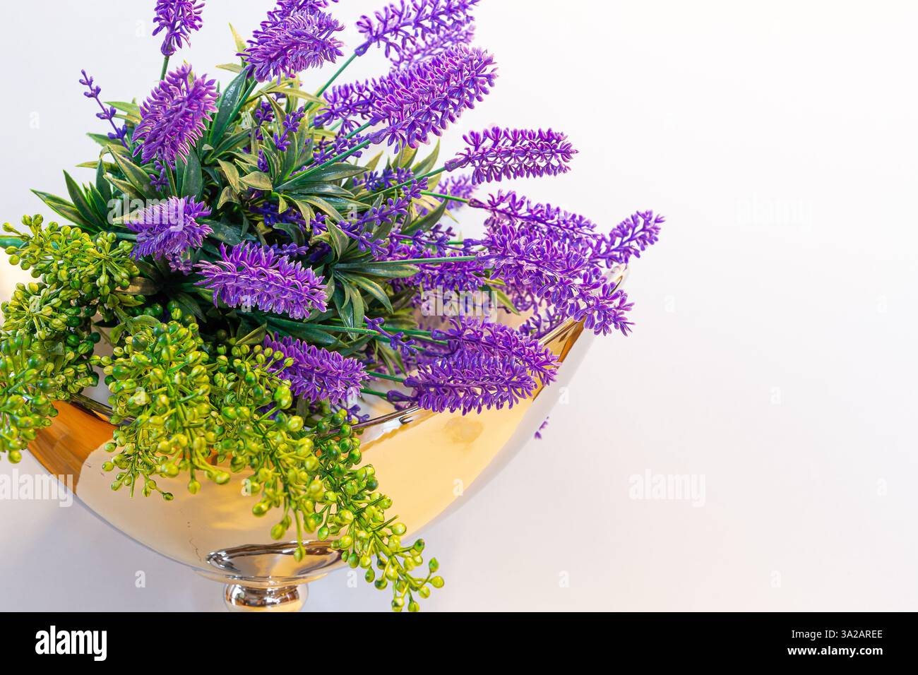 Composizione del bouquet di fiori di lavanda in un vaso dorato su sfondo bianco, decorazioni primaverili. Foto Stock