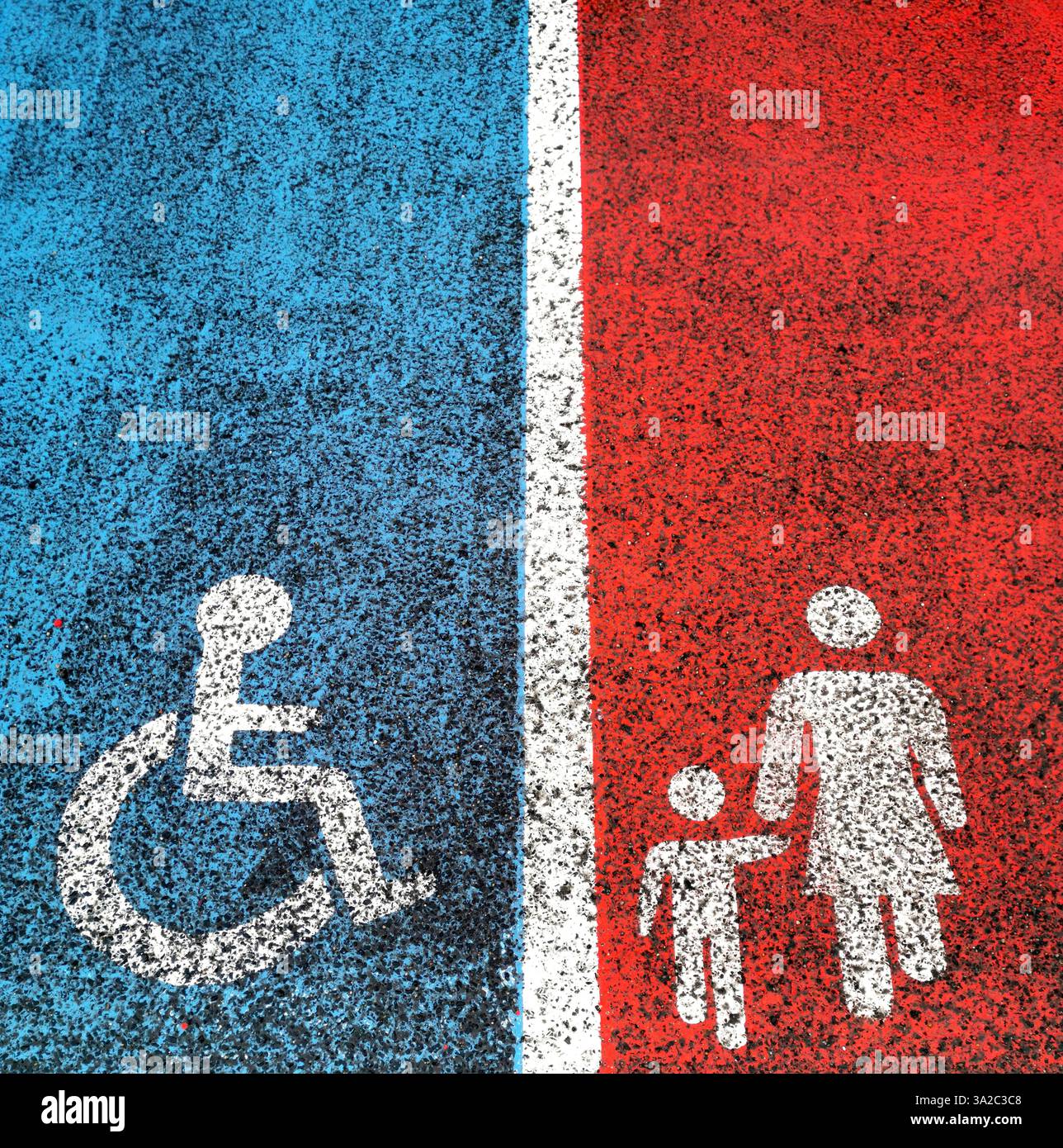 Simboli di parcheggio per persone disabili e famiglie esposti sul marciapiede in sezioni blu e rosse con contrassegni chiari Foto Stock
