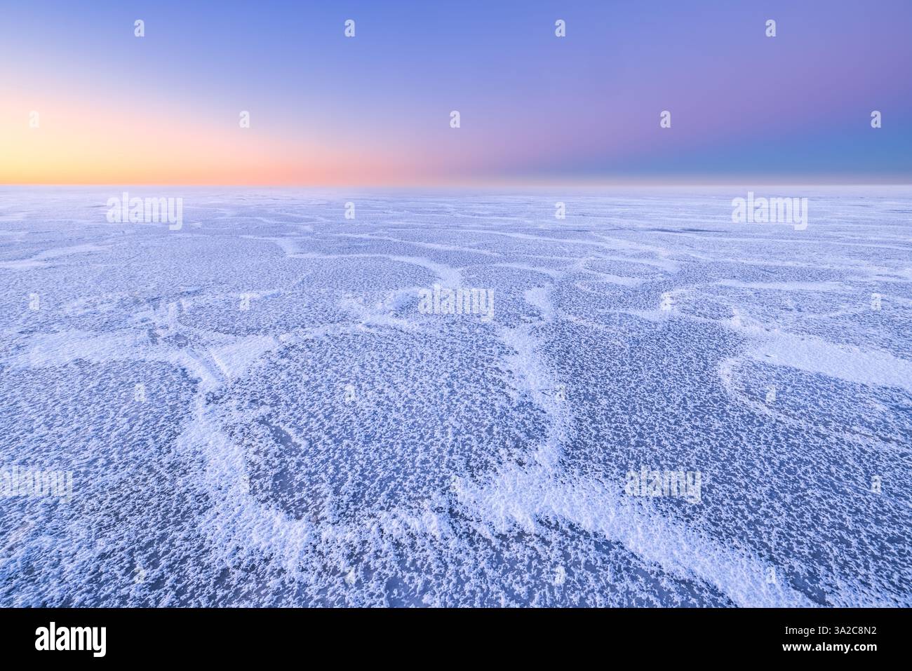 Un paesaggio polare con un lago ghiacciato e colori pastello del tramonto in inverno - un paesaggio invernale Foto Stock Un paesaggio polare con un lago ghiacciato e colori pastello del tramonto in inverno - un paesaggio invernale Foto Stock