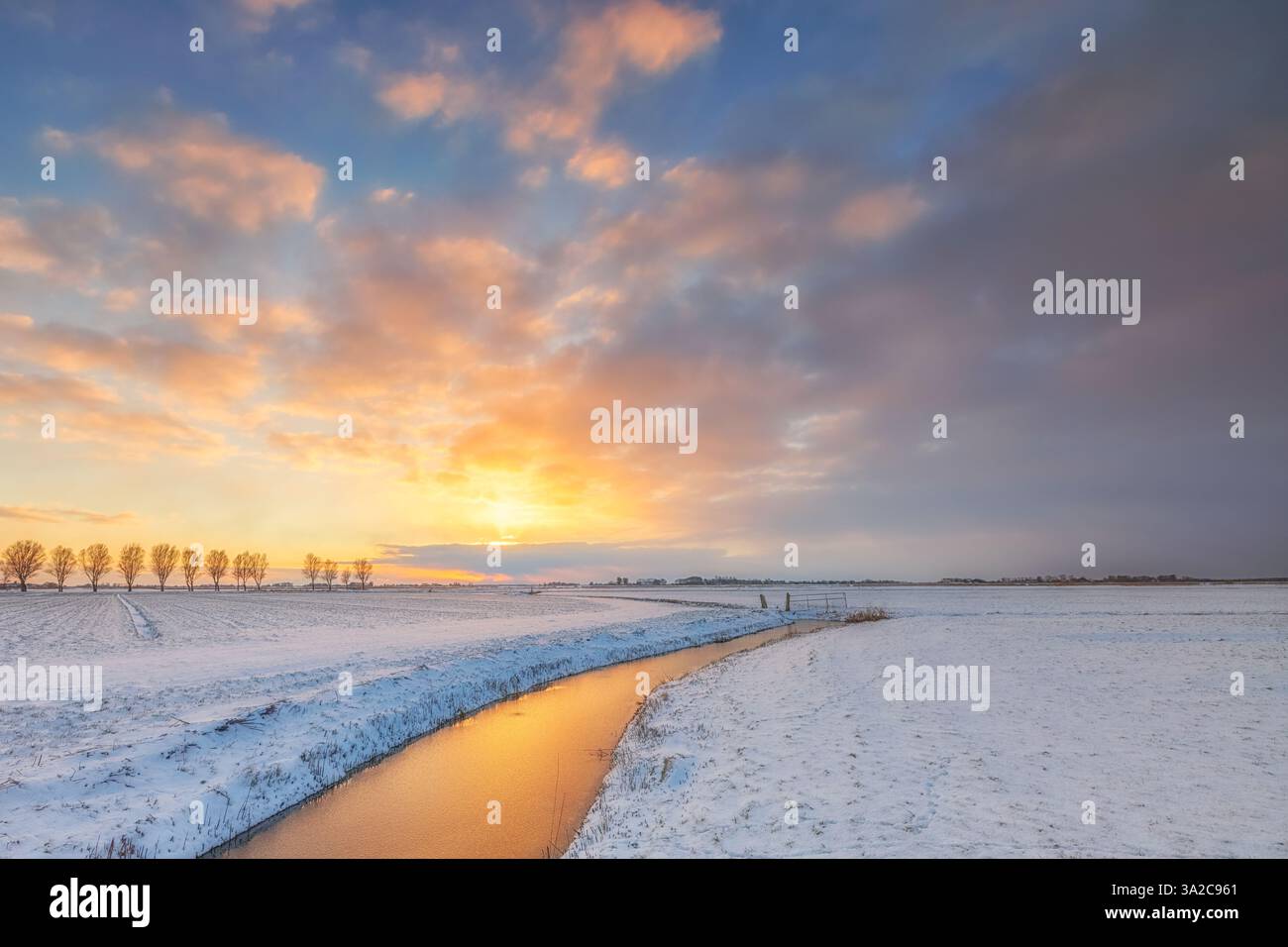 Un paesaggio invernale di campagna con neve al tramonto con splendidi colori nel cielo a Groninga, nei Paesi Bassi - un paesaggio freddo e ghiacciato Foto Stock Un paesaggio invernale di campagna con neve al tramonto con splendidi colori nel cielo a Groninga, nei Paesi Bassi - un paesaggio freddo e ghiacciato Foto Stock