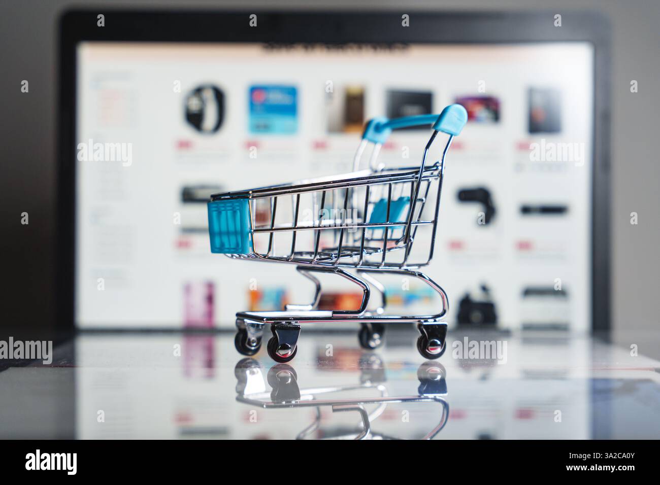 Un piccolo carrello davanti a una pagina Web di un negozio online, che rappresenta il commercio digitale, lo shopping su Internet e le tendenze moderne del retail. ph di alta qualità Foto Stock