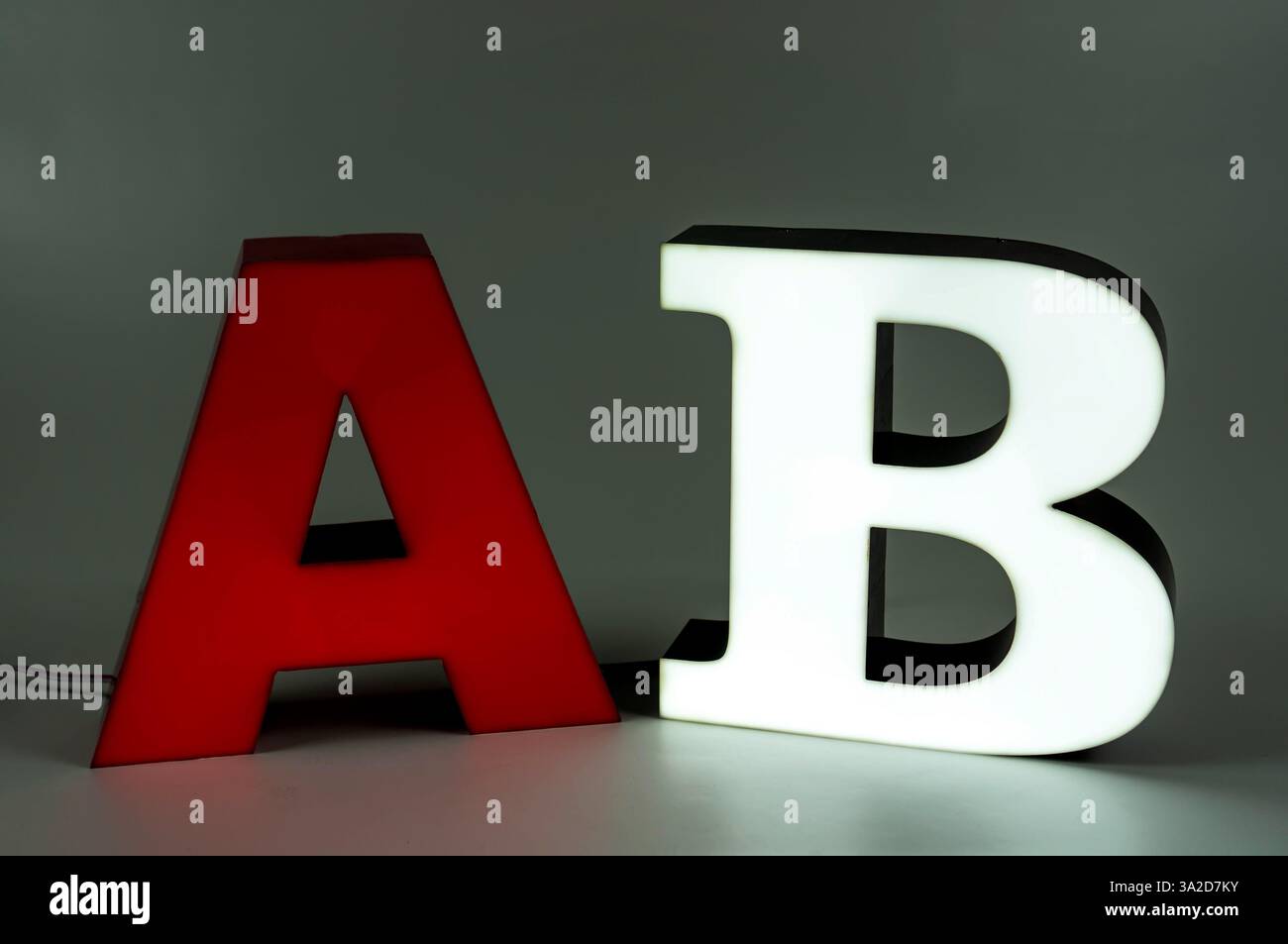 Le lettere volumetriche luminose A e B fanno parte di un cartello pubblicitario. Parete laterale in alluminio. Rosso, bianco Foto Stock