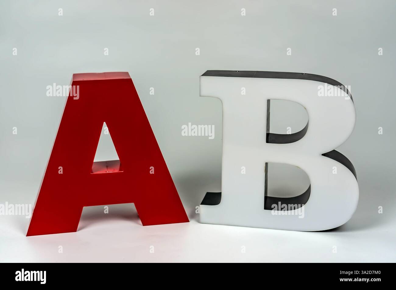 Le lettere volumetriche A e B fanno parte di un cartello pubblicitario. Rosso e bianco. Nessuna luce. Foto Stock