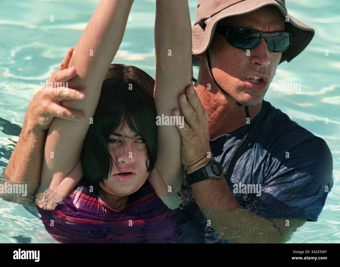 Tom Riley, l'istruttore di aquatics, mostra a Jennifer Keeler e al resto dei bambini del campo estivo il modo giusto per tenere le mani davanti alla testa mentre si passa attraverso l'acqua nella piscina della Sacramento State University. Quest'estate, un nuovo programma che permette ai bambini con disabilità fisiche di sperimentare i campi estivi. Questi sono bambini di solito lasciati fuori dai tradizionali campi estivi. Il campo è sponsorizzato da Sac State e va dal 30 luglio al 3 agosto. Foto scattata 8/1/00. (Credito: © Sacramento Bee/ZUMAPRESS.com) Foto Stock