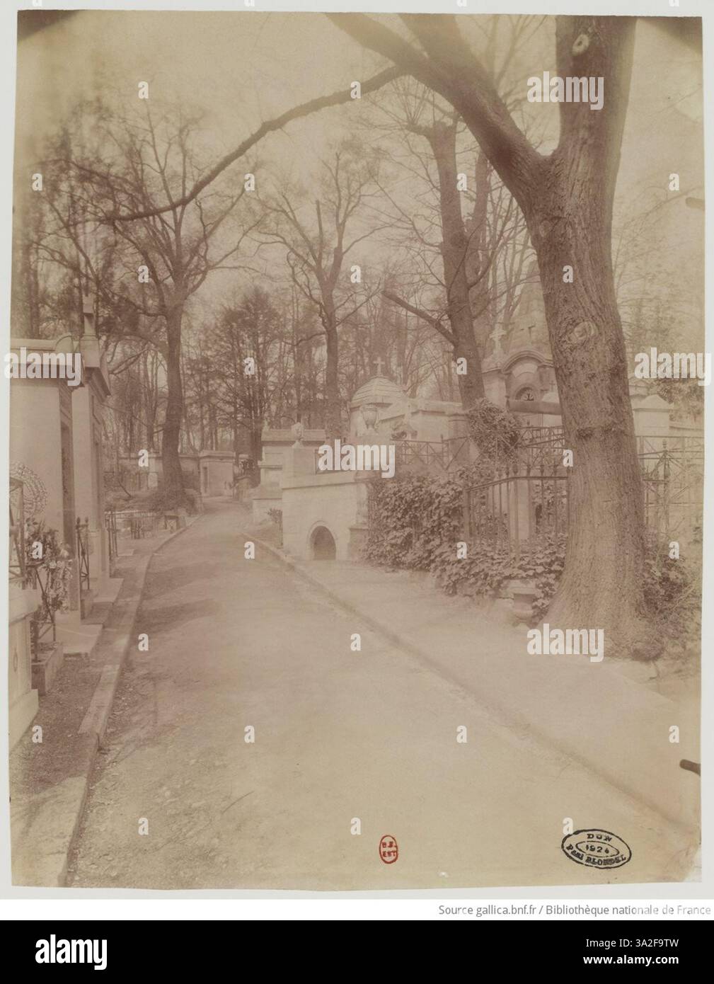 La fotografia di Père Lachaise di Eugène Atget cattura la qualità pacifica e riflettente del cimitero, con particolare attenzione alle lapidi e al significato storico generale del sito. Foto Stock