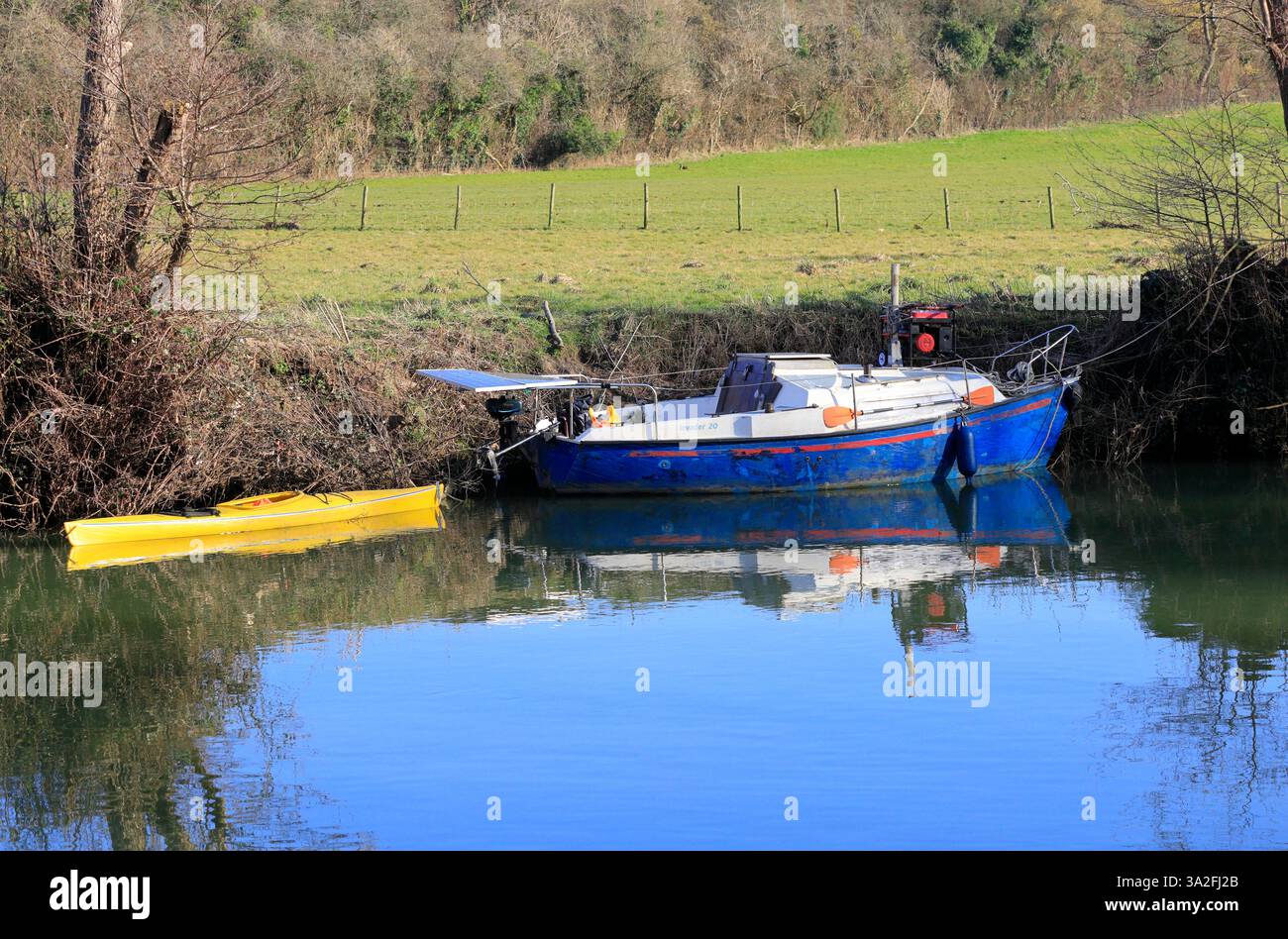Barca e kayak giallo ormeggiati su una riva del fiume, Saltford, vicino a Bristol, Inghilterra, Inghilterra sud-occidentale, REGNO UNITO. Presa a marzo 2025 Foto Stock