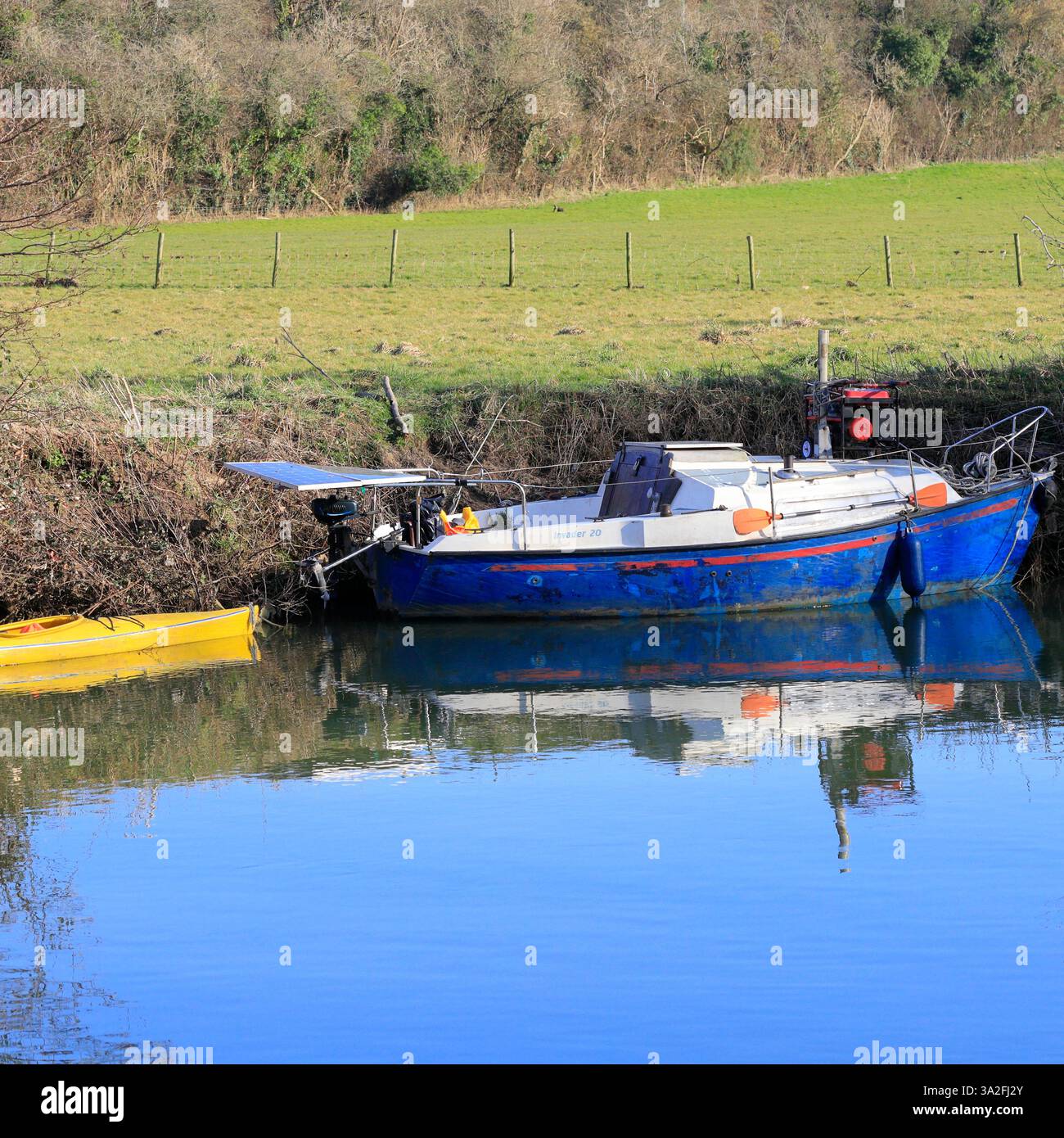 Barca e kayak giallo ormeggiati su una riva del fiume, Saltford, vicino a Bristol, Inghilterra, Inghilterra sud-occidentale, REGNO UNITO. Presa a marzo 2025 Foto Stock