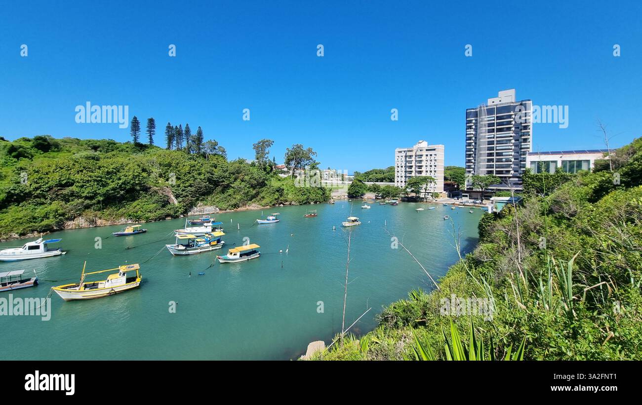 Una splendida scena costiera con vibranti acque turchesi, lussureggianti isole verdi e una serie di barche colorate che galleggiano dolcemente sul mare calmo. - Immagine stock catturata con smartphone