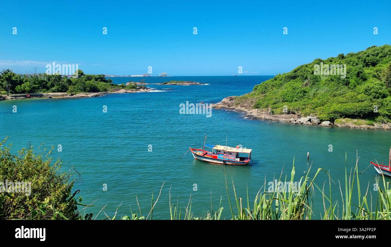 Una splendida scena costiera con vibranti acque turchesi, lussureggianti isole verdi e una serie di barche colorate che galleggiano dolcemente sul mare calmo. - Immagine stock catturata con smartphone