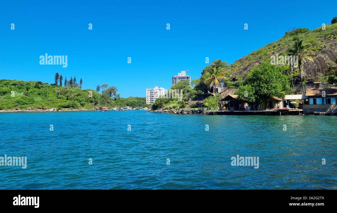 Un tranquillo scenario sul lungomare dove natura e abitazioni umane si fondono armoniosamente. Foto Stock
