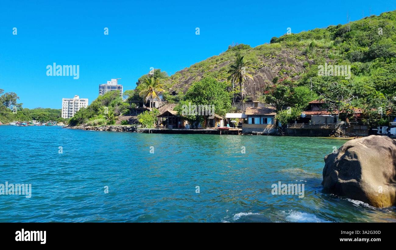 Un tranquillo scenario sul lungomare dove natura e abitazioni umane si fondono armoniosamente. Foto Stock