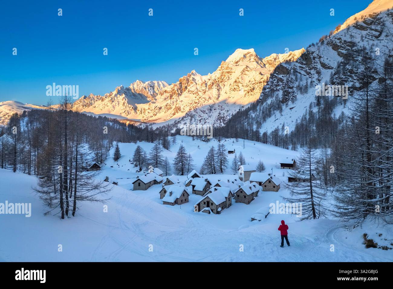 Una persona che ammira Crampiolo in inverno all'Alpe Devero. Alpe Devero, valle dell'Ossola, Piemonte, Verbano Cusio Ossola, Piemonte, Italia. Foto Stock
