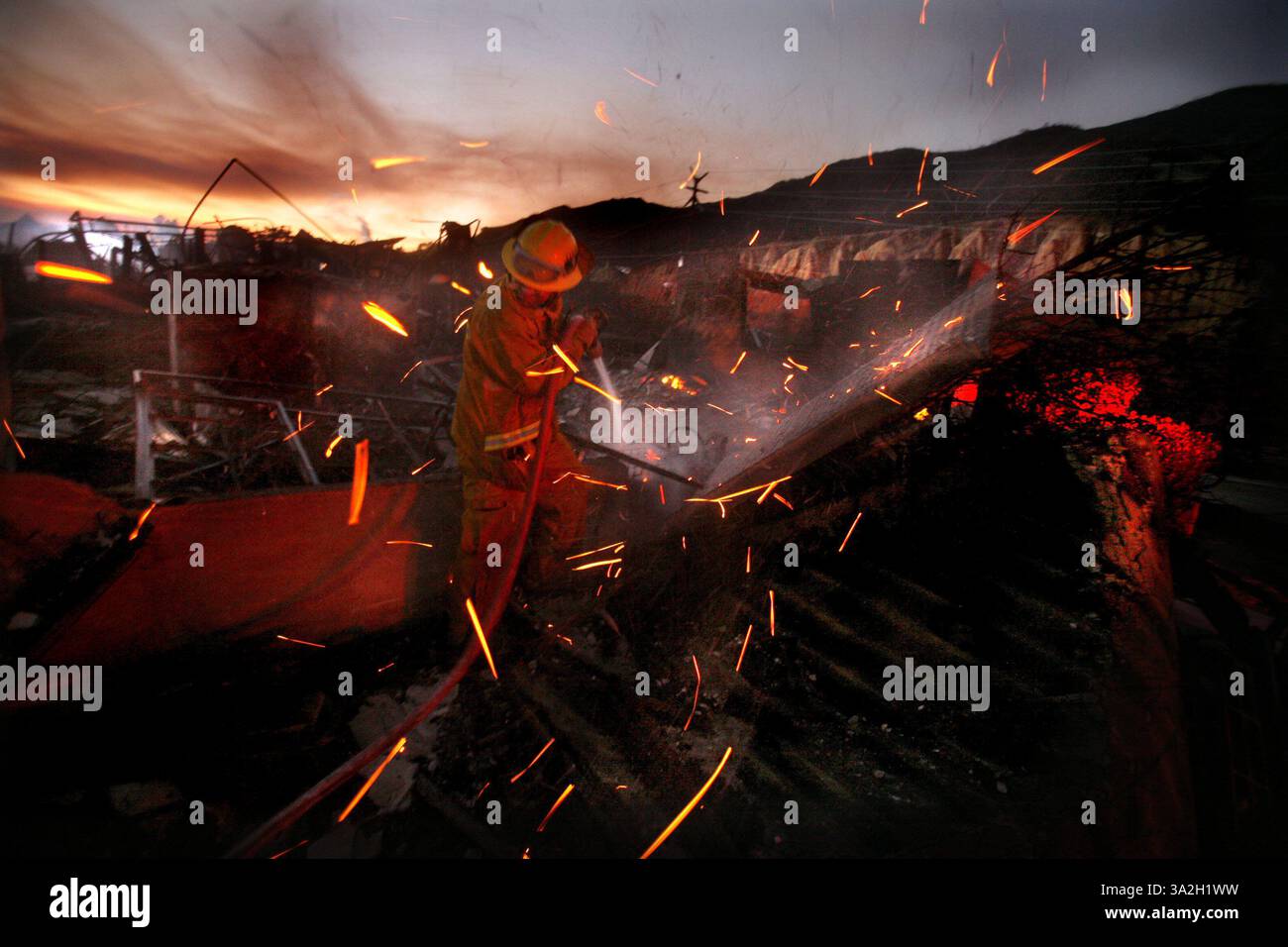 La domenica sera, un vigile del fuoco della contea di Los Angeles mette l'acqua sulla chiesa presbiteriana di Malibu sulla Malibu Canyon Drive vicino all'Università di Pepperdine a Malibu. 21 ottobre 2007, FUOCO ONLINE DIDASCALIA Embers girano tra i venti forti mentre un vigile del fuoco della contea di Los Angeles mette l'acqua sulla chiesa presbiteriana di Malibu su Malibu Canyon Drive vicino alla University of Pepperdine a Malibu domenica sera. Showcase 2007 (credito: © Sacramento Bee/ZUMAPRESS.com) Foto Stock