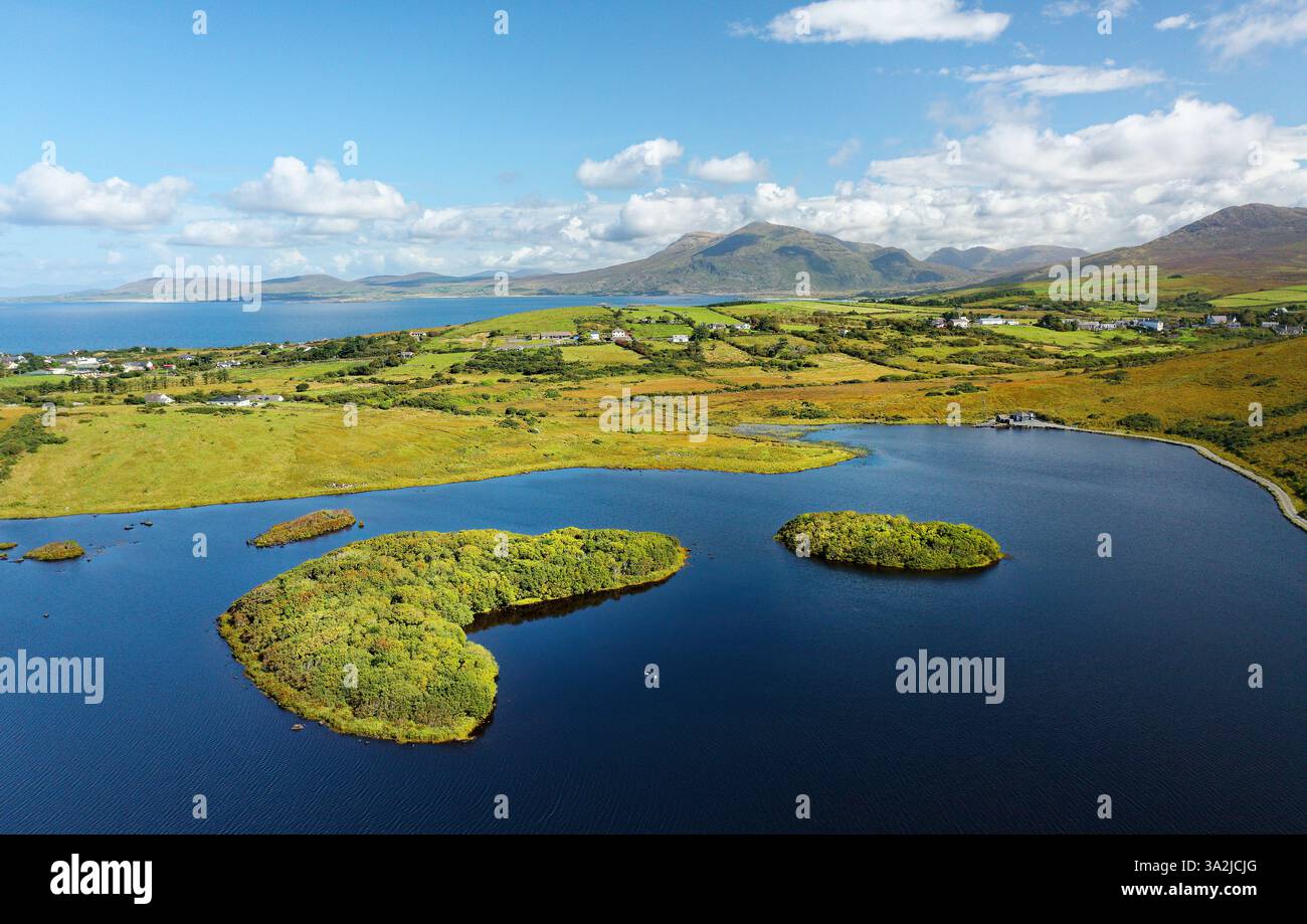 A nord-est sul Tully Lough fino al monte Mweelrea. Connemara settentrionale, Irlanda. L'isola sulla destra è un insediamento artificiale artificiale artificiale artificiale artificiale di crannog preistorico Foto Stock