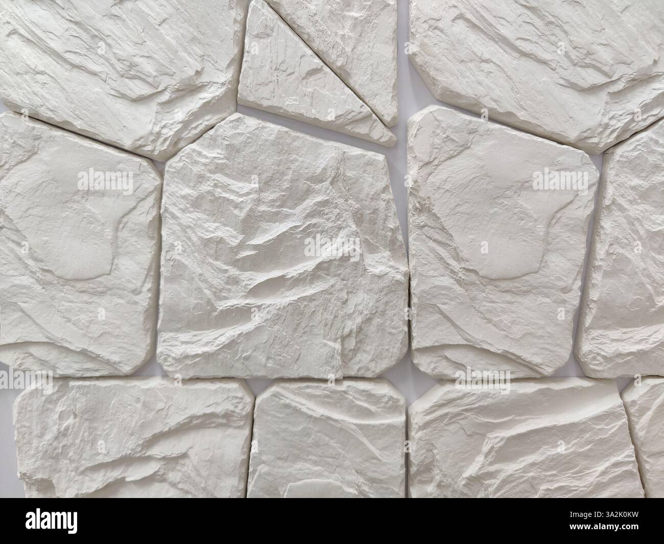 Decorazione murale con pietra grigio selvatico artificiale di forma arbitraria. Lavori di finitura, rivestimenti murali. Primo piano. Foto Stock