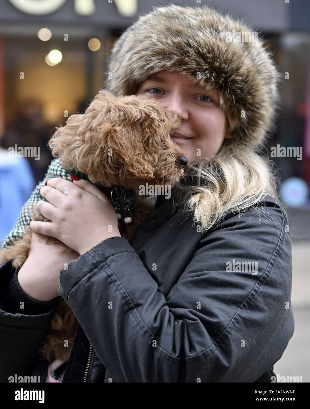 Ritratto donna con cappello di pelliccia che tiene in mano il cane Foto Stock