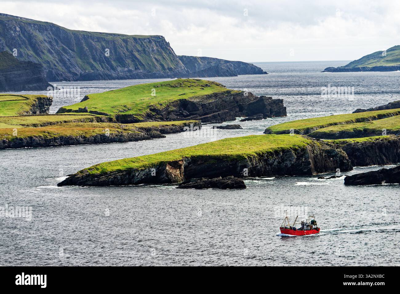 Le 1000ft Kerry Cliffs a ovest della penisola di Iveragh Ring of Kerry e sulla Wild Atlantic Way. Visto da Bray Head, Valentia. Barca da pesca di ritorno Foto Stock