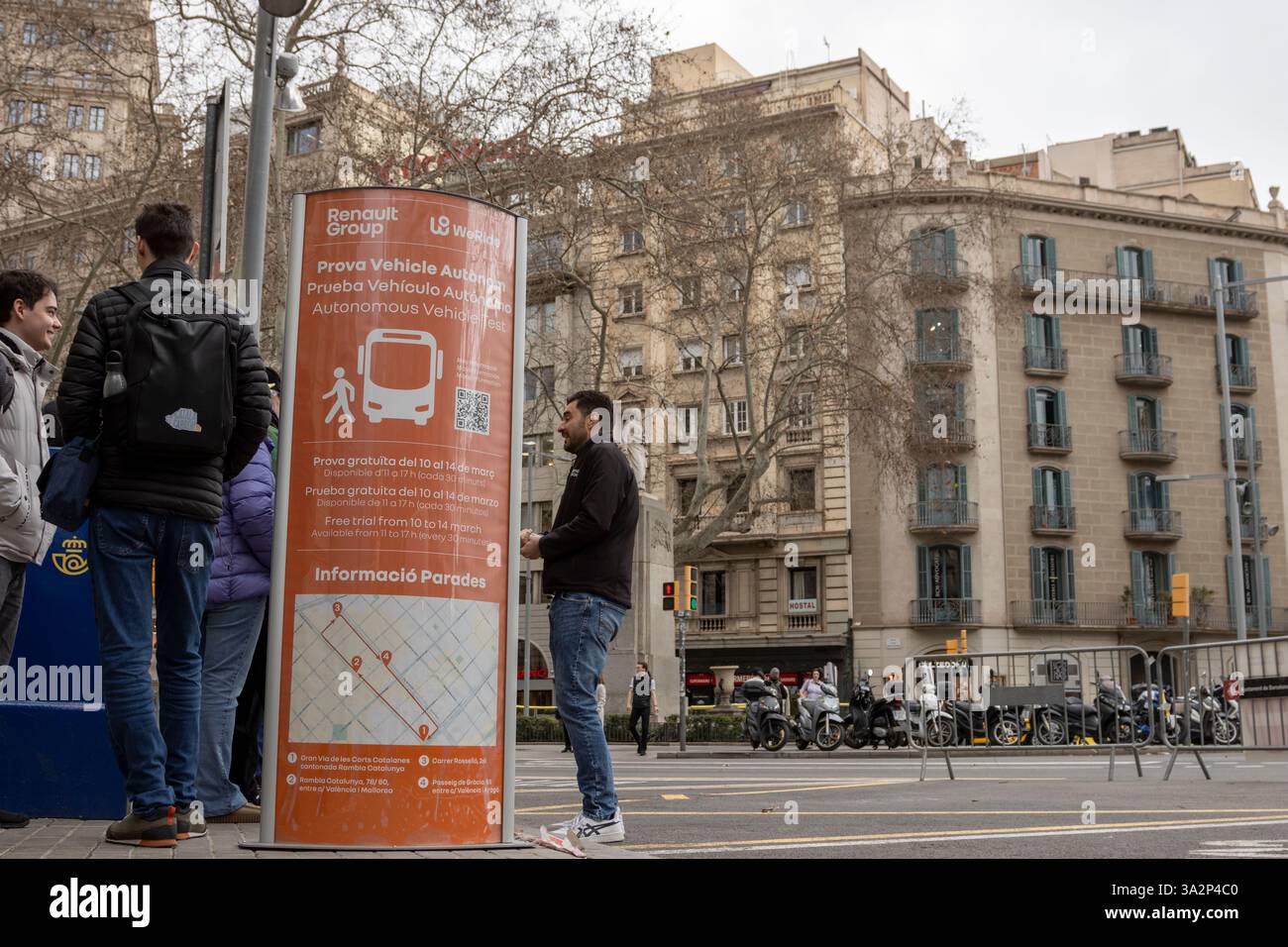 La gente aspetta un autobus che viaggia da sola vicino al Passeig Gracia a Barcellona. In genere lo aspettano per più di un'ora. Foto Stock