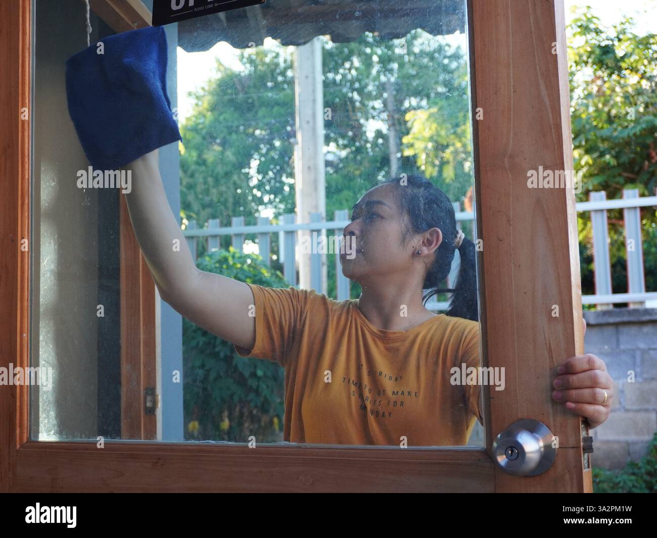 Donna asiatica adulta che fa il lavoro di casa a casa. Foto Stock