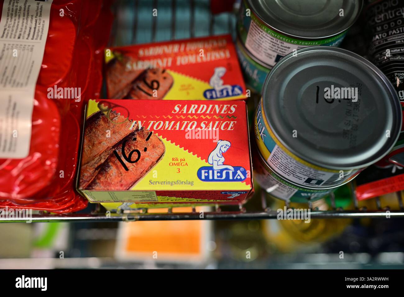 Vinslöv, Skåne, Svezia. 13 marzo 2025. Piccolo minimarket sulla piazza di Vinslöv. Sardine in scatola in salsa di pomodoro. Foto Stock