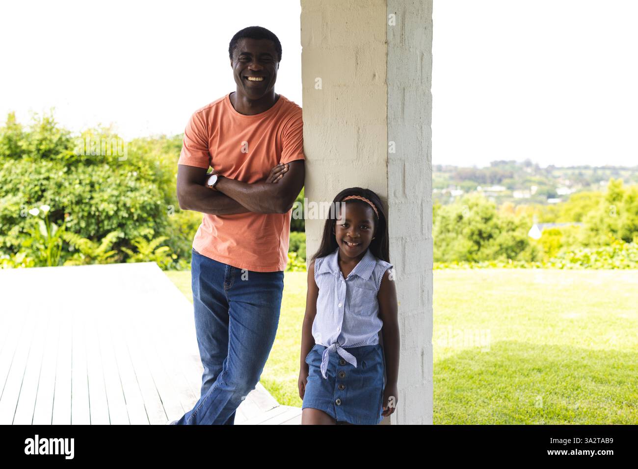 Padre e figlia afroamericani sorridenti all'aperto, godendosi momenti di qualità insieme in giardino Foto Stock