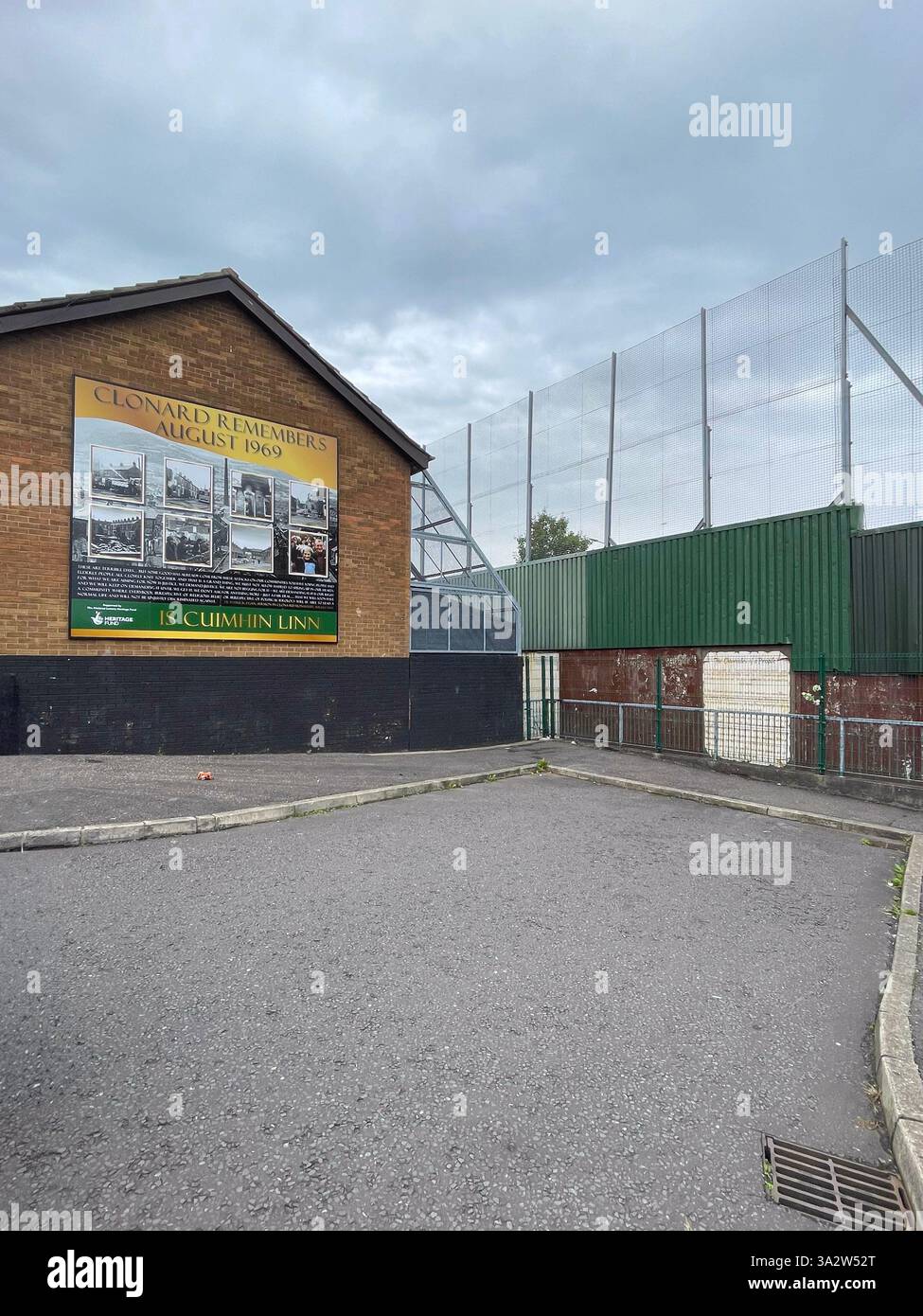 Una sezione del muro della pace di Belfast con un memoriale dietro le ringhiere di ferro, che simboleggia il passato diviso della città. Foto Stock