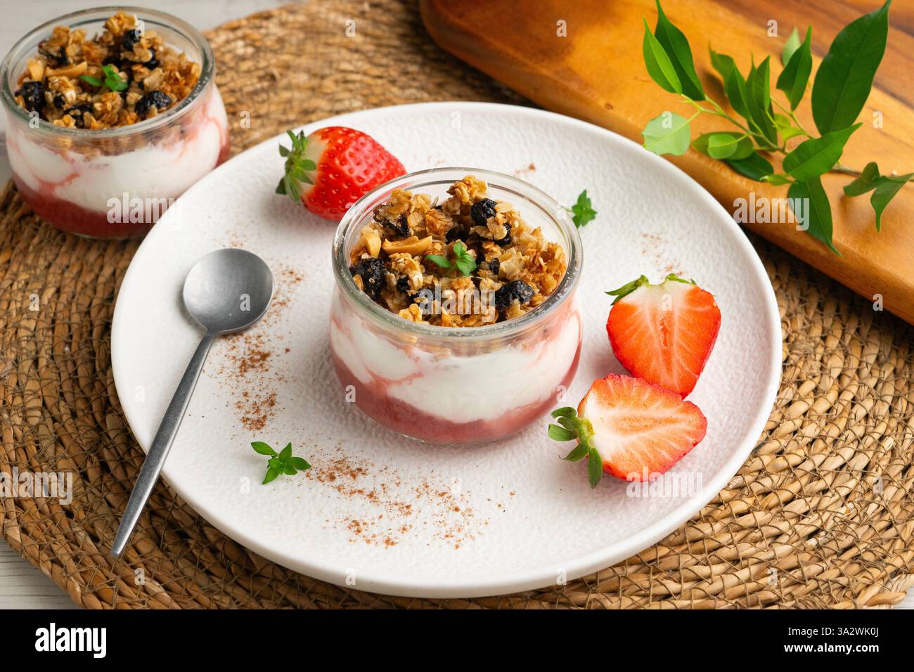Yogurt greco con fragole e muesli a base di cereali e noci. Foto Stock