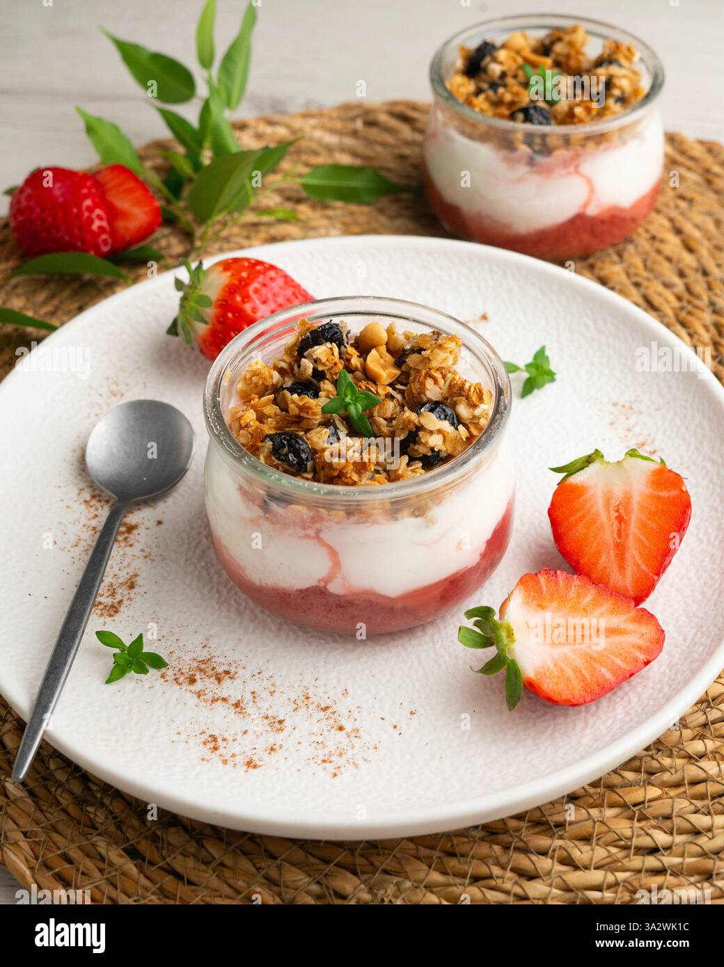 Yogurt greco con fragole e muesli a base di cereali e noci. Foto Stock