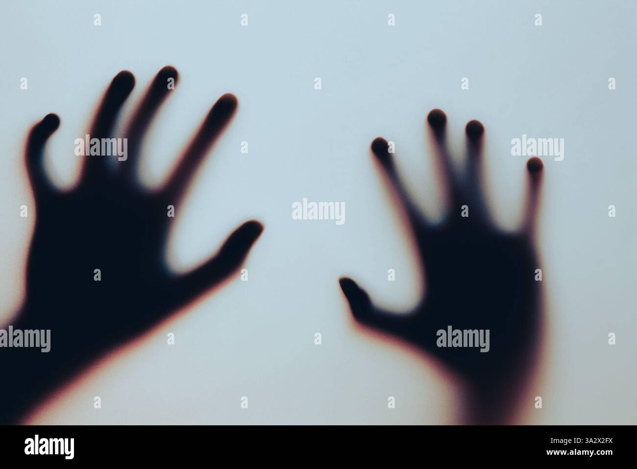 Una silhouette di due mani premute contro una superficie traslucida crea un'atmosfera misteriosa e sospettosa. L'effetto sfocato aggiunge fascino e fascino Foto Stock