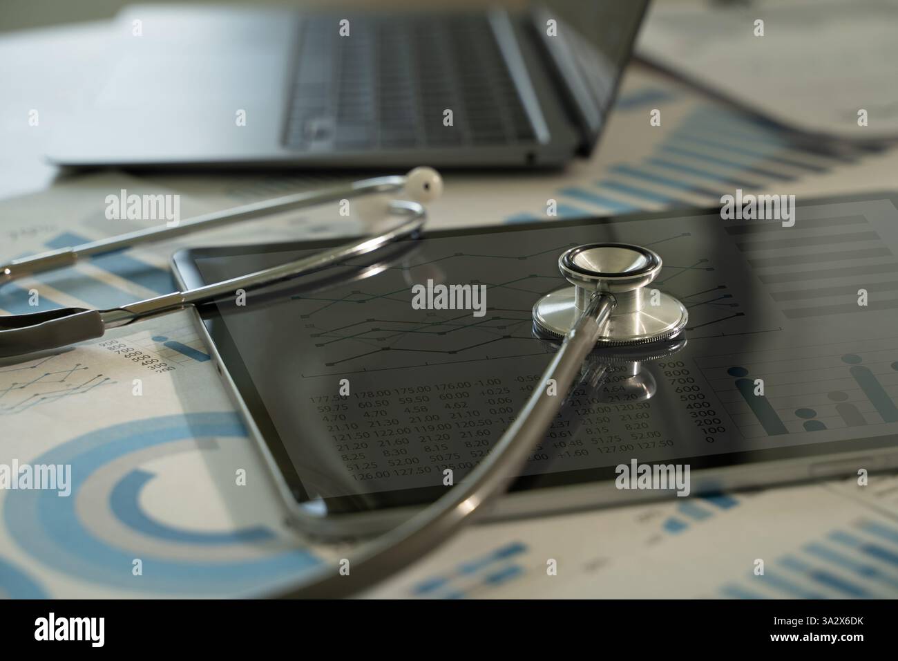 Il medico utilizza la tecnologia moderna e l'analisi medica per migliorare la cura dei pazienti. Ricerca sul lavoro medico monitoraggio con stetoscopio e grafici Foto Stock