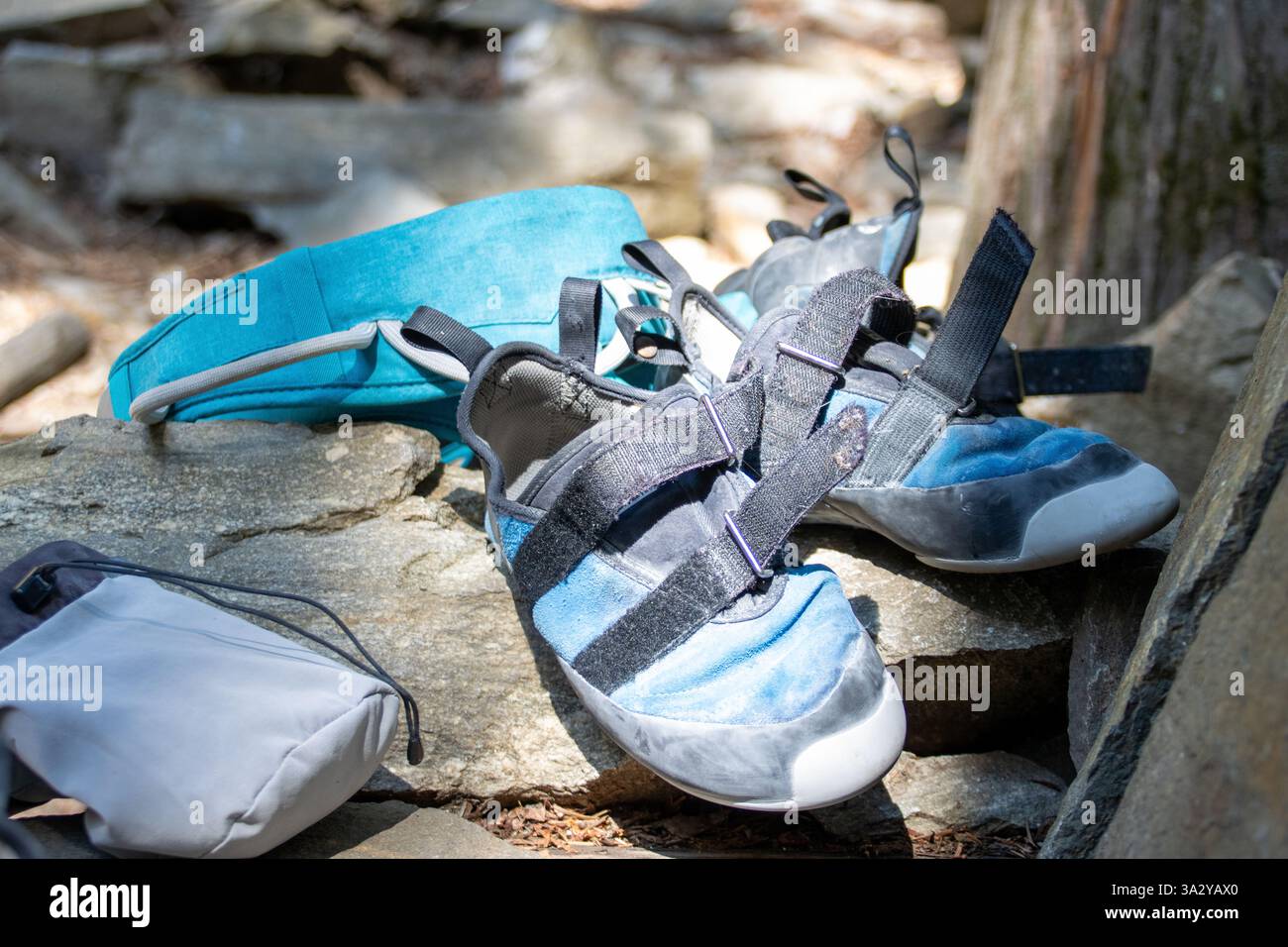 Attrezzatura e scarpe da arrampicata ben usate su una roccia al sole. Foto Stock