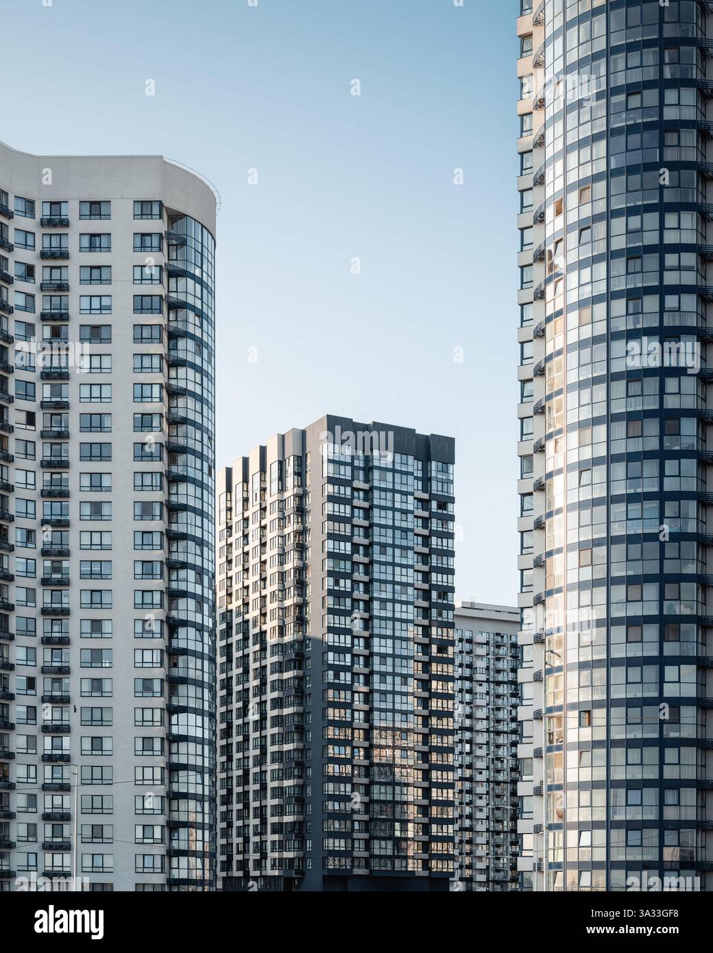Quartiere moderno con alti edifici residenziali. Facciate di eleganti condomini al tramonto. Foto Stock