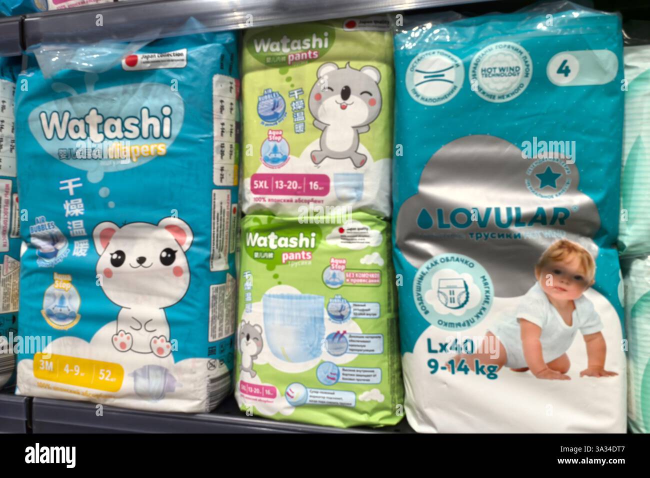 Bobruisk, Bielorussia - 2 marzo 2025: Pannolini confezionati in modo brillante sono disposti sugli scaffali di un corridoio di negozi, con design adorabili. I genitori sfogliano le opzioni a. Foto Stock