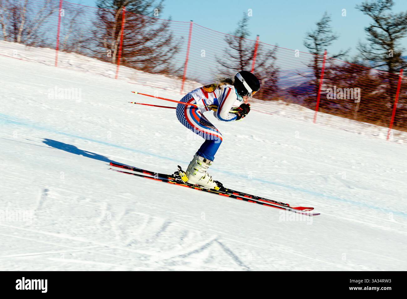 donna sciatrice in discesa, pista coperta da neve, segnata durante lo sci alpino agonistico Foto Stock