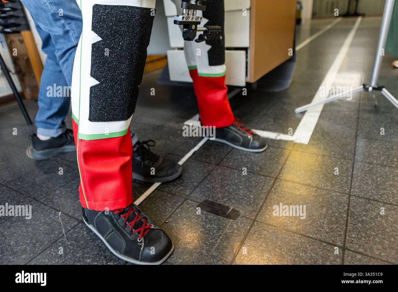 Primo piano delle attrezzature adattive utilizzate per il tiro olimpico cieco. Abbigliamento e tecnologia specializzati per la precisione e il sostegno nello sport. Foto Stock