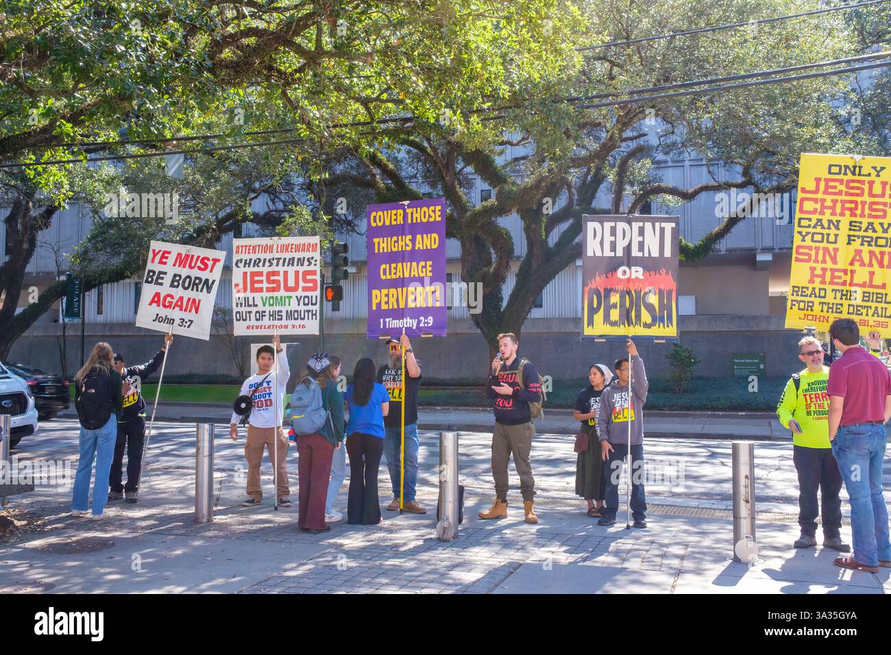 New Orleans, LOUISIANA, USA - 28 febbraio 2025: Piccolo gruppo di cristiani evangelici fondamentalisti con segni che coinvolgono gli studenti sul peccato e la dannazione all'ingresso del campus universitario di Tulane Foto Stock