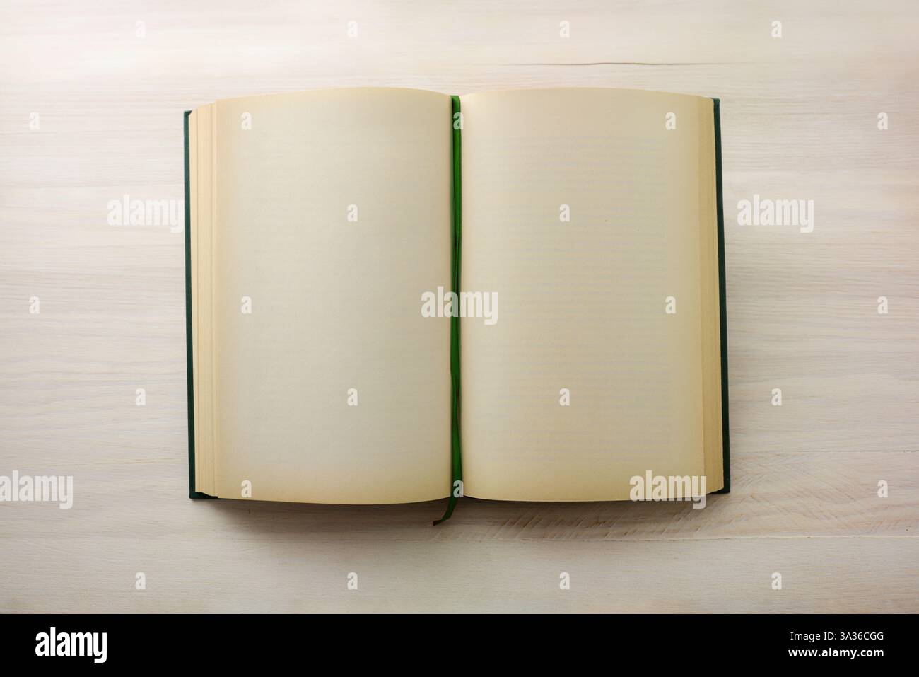 Libro vintage con nastro di registrazione verde aperto con pagine vuote su un tavolo di legno. Vista dall'alto. Foto Stock