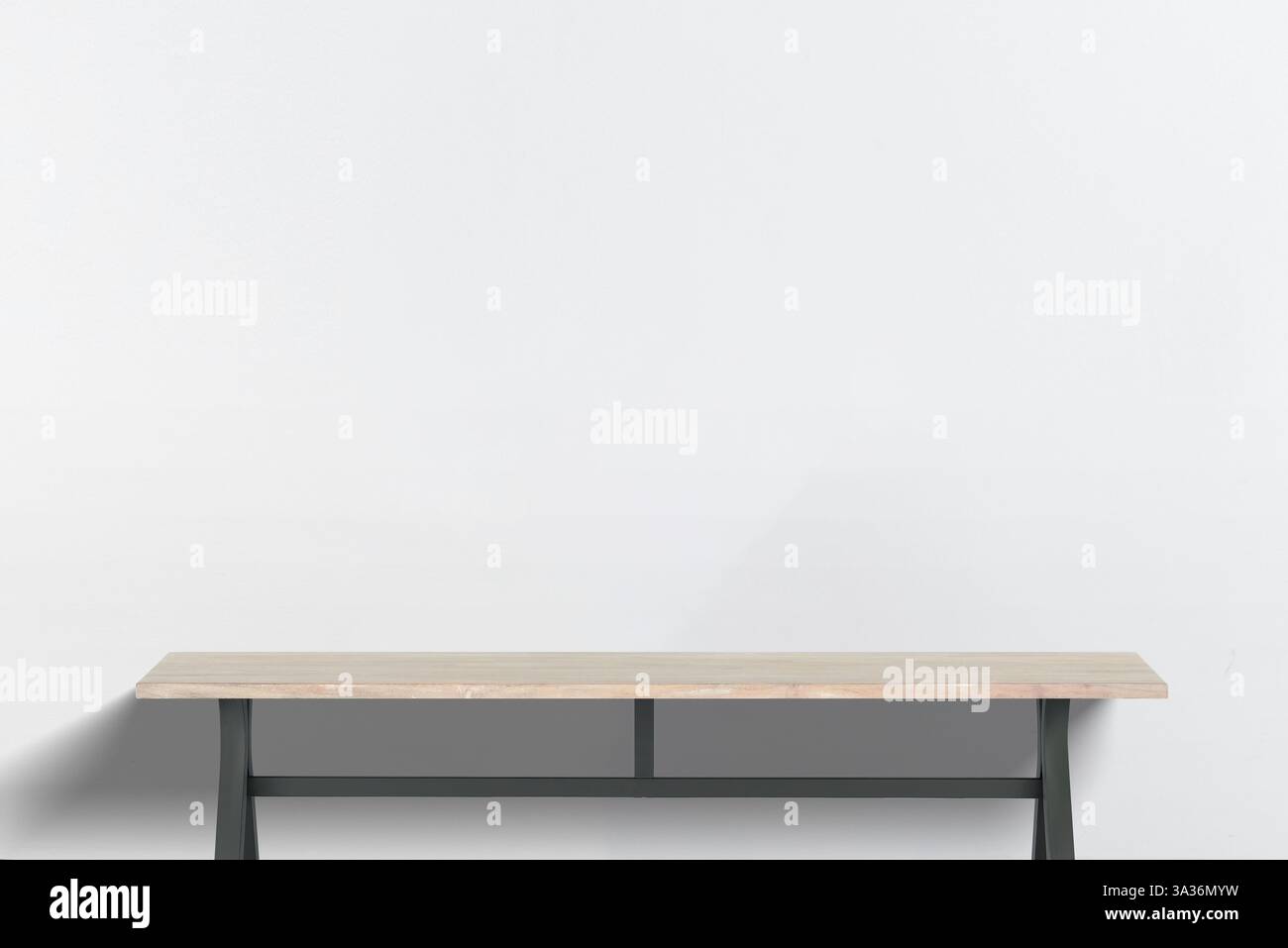 Scrivania minimalista in legno con gambe in metallo nero, spazio di lavoro vuoto su una parete bianco-grigio, perfetta per allestimenti in ufficio, esposizione di prodotti o lavori creativi Foto Stock
