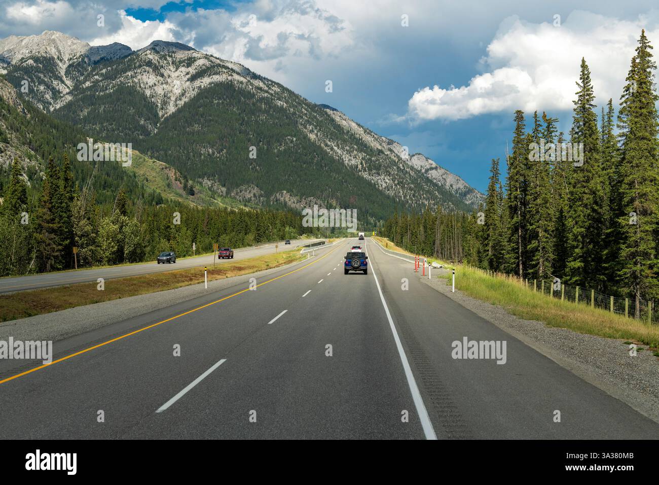 Veicoli che viaggiano sulla Trans Canada Highway tra Calgary e il parco nazionale di Banff con vista sulle Montagne Rocciose canadesi, Canada. Foto Stock