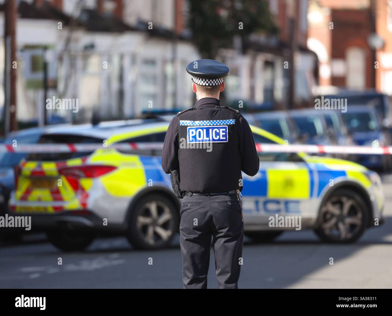 Agente di polizia fotografato da dietro su una scena del crimine nel Regno Unito. Foto Stock